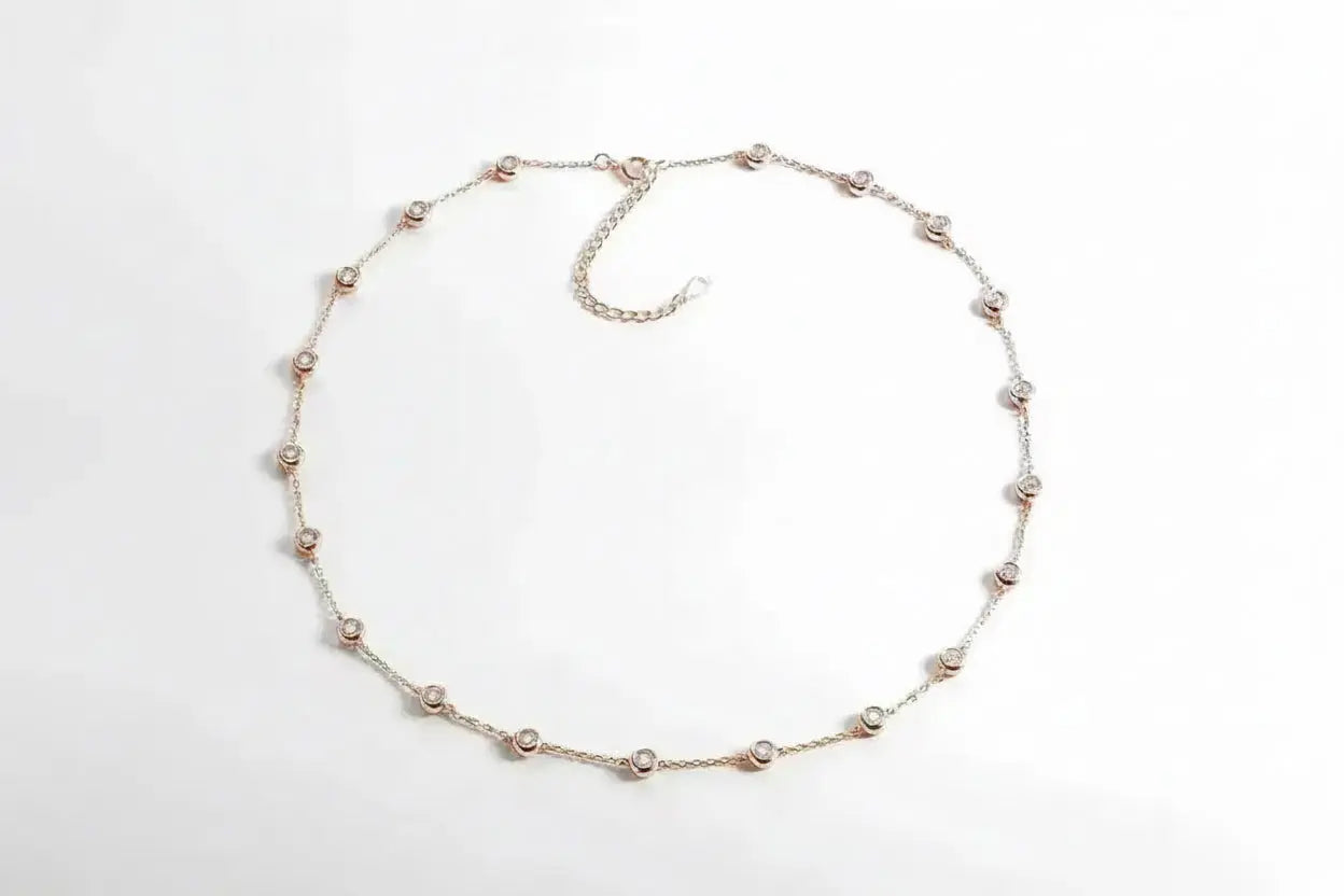Shiny gold Classic Tennis Necklace by Zethech with a seamless row of linked, sparkling chain links on a plain background.