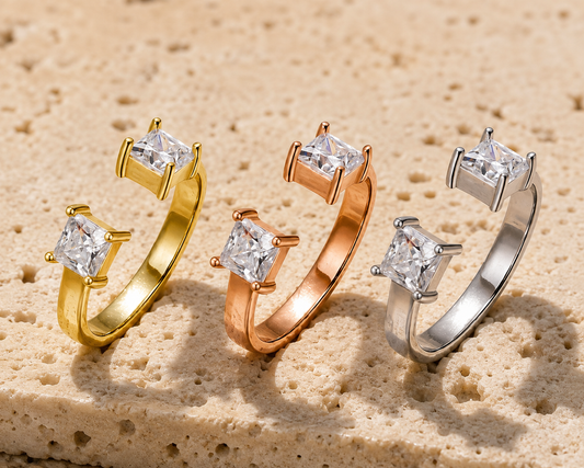 Princess-cut moissanite open rings in gold, rose-gold and silver tones on beige stone