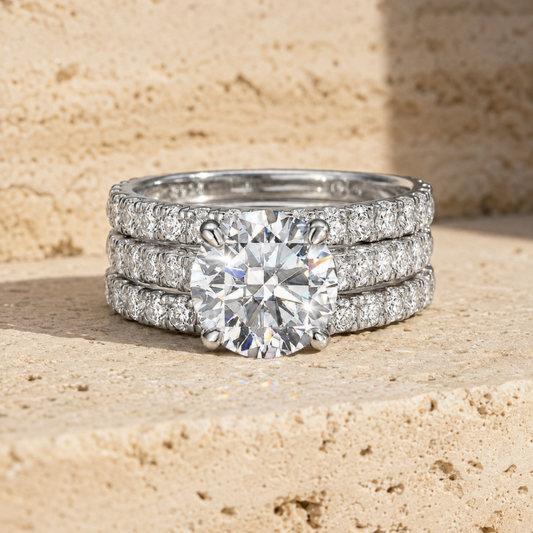 Front view of a silver-tone bridal ring stack with a round moissanite center and pave bands