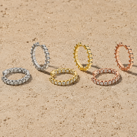Classic moissanite hoop earrings in white, yellow and rose gold-plated finishes on travertine