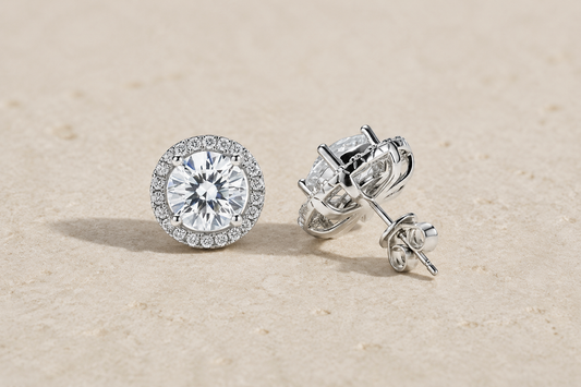 Moissanite halo stud earrings showing a round center, pavé halo and side profile on travertine