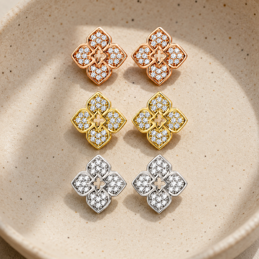 Flower moissanite stud earrings in white, yellow and rose gold-plated finishes in a ceramic dish