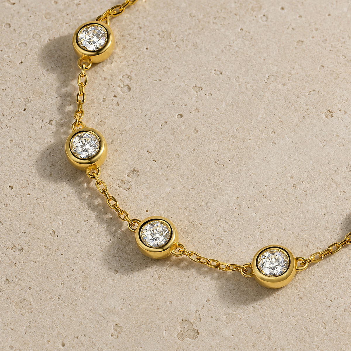 
תקריב של צמיד מכסף 925 בשיבוץ מואסנייט עם שמונה אבנים עגולות בציפוי זהב צהוב