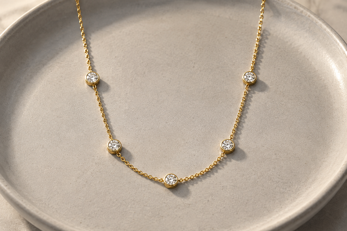 
תקריב של שרשרת תחנות מכסף 925 משובצת באבני מואסנייט עגולות בשיבוץ כוס בציפוי זהב צהוב