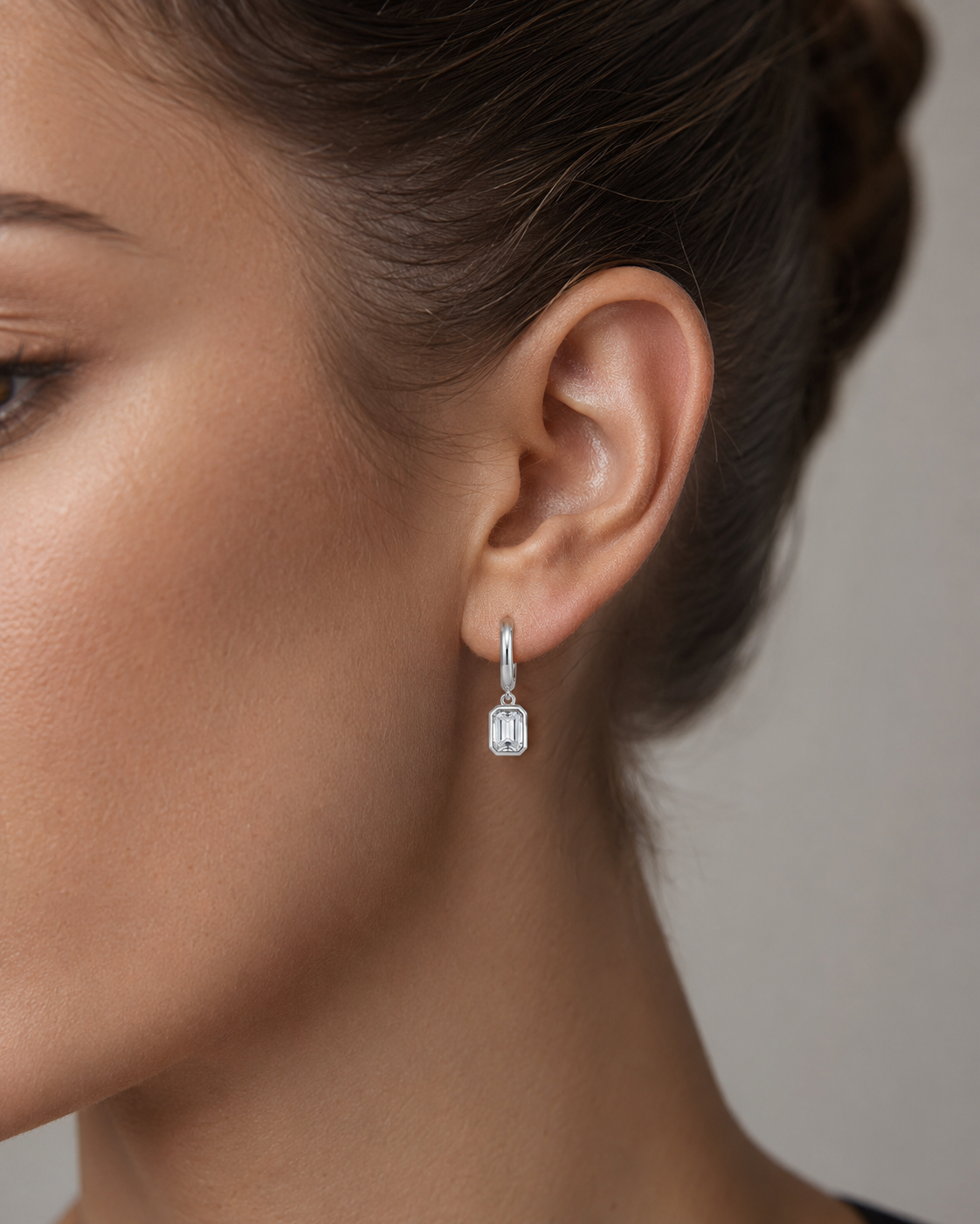 Close-up of Zethech Signature Emerald Drops worn on ear in silver with clear stone detail