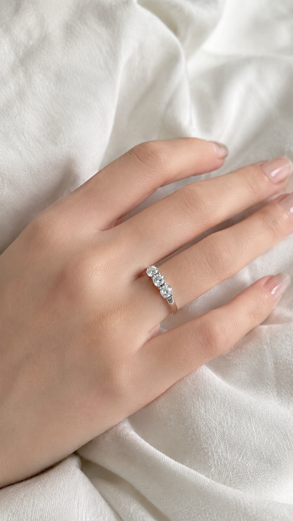 Zethech Halo Round Ring worn on hand against white fabric background