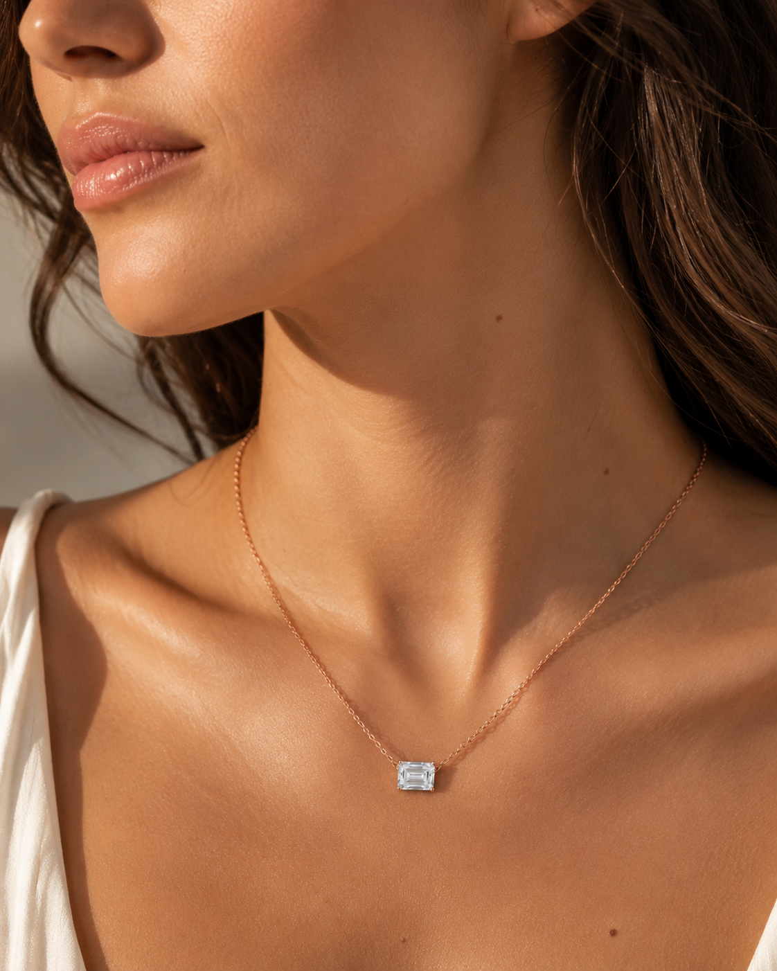 Close-up of Zethech Verona Emerald Necklace worn with emerald-cut pendant