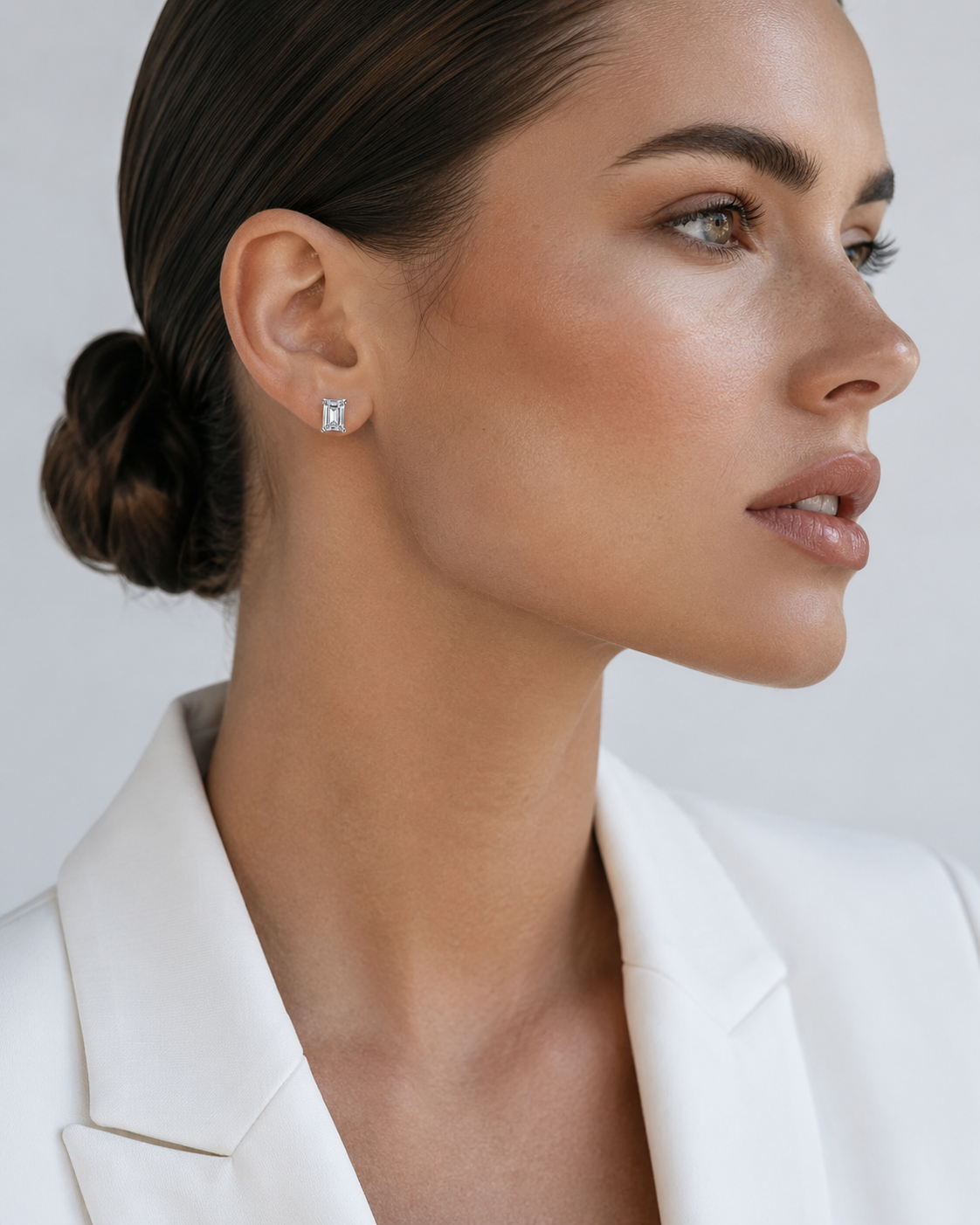 Zethech Luna Emerald Studs worn on ear with plain background
