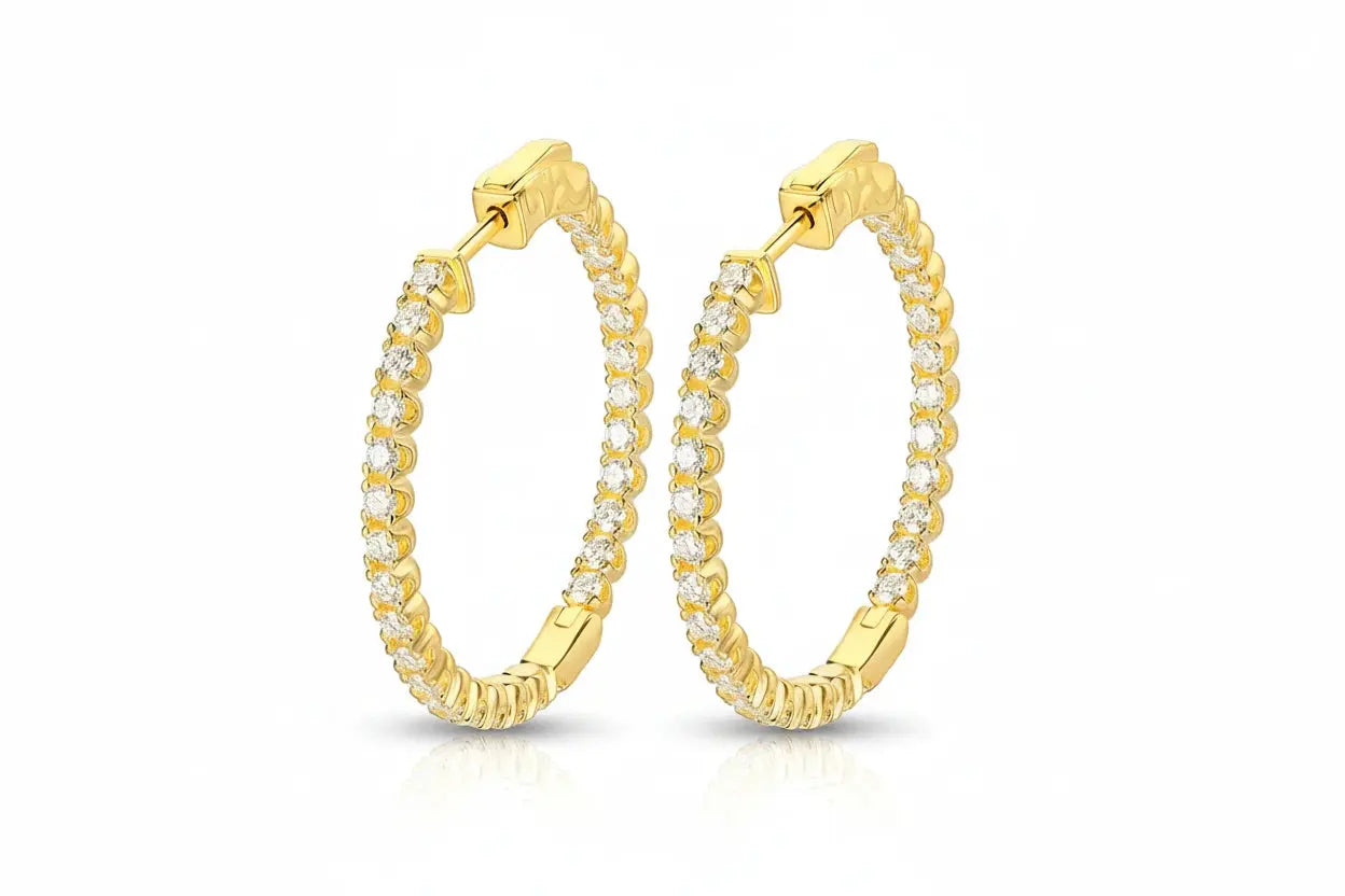 Gold hoop earrings with clear stones on a white background