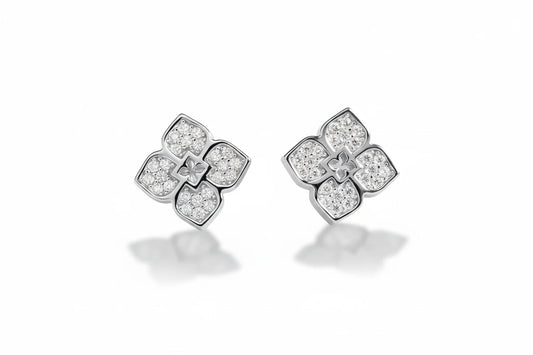Zethech flower-shaped moissanite stud earrings with sparkling gemstones and silver posts on a white background.
