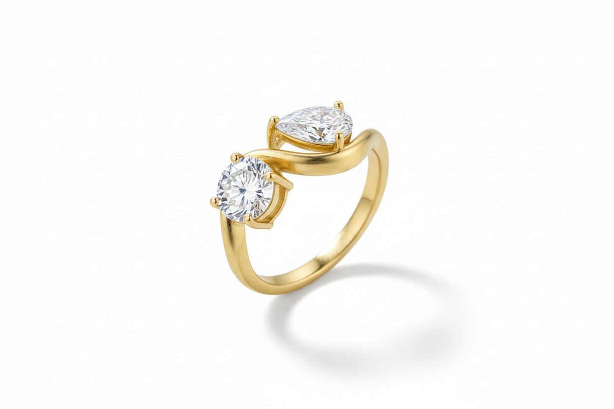 Silver ring with two oval-shaped diamonds on a green background